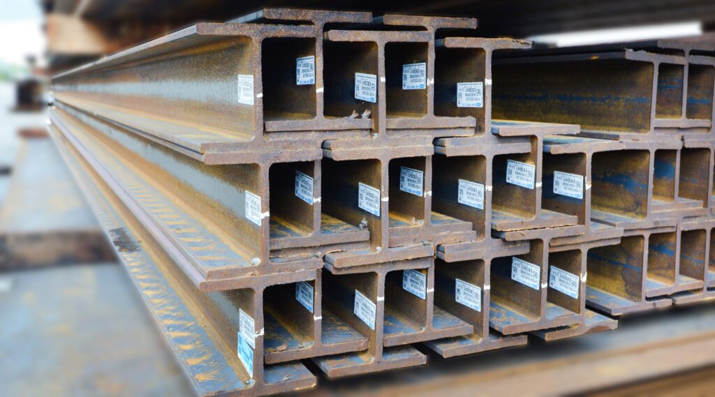 Stacked steel beams identified with individual inventory labels